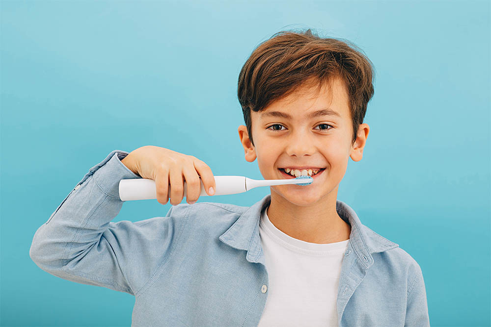 boy using electric toothbrush